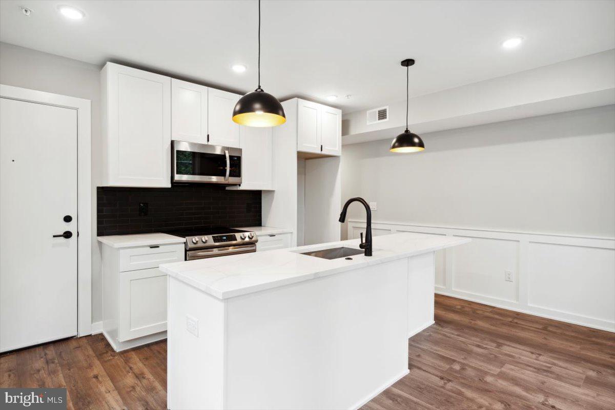 3519 Hamilton Street, Unit A Philadelphia, PA 19104 - Photo 28 of 47 a kitchen with stainless steel appliances a white table chairs and a refrigerator