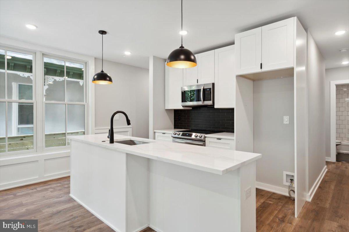 3519 Hamilton Street, Unit A Philadelphia, PA 19104 - Photo 6 of 47 a kitchen with stainless steel appliances a stove a sink a refrigerator and a microwave