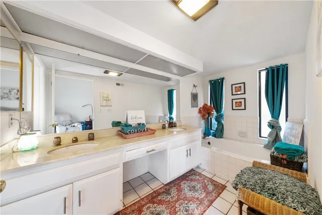 a spacious bathroom with double vanity sinks a mirror and a shower