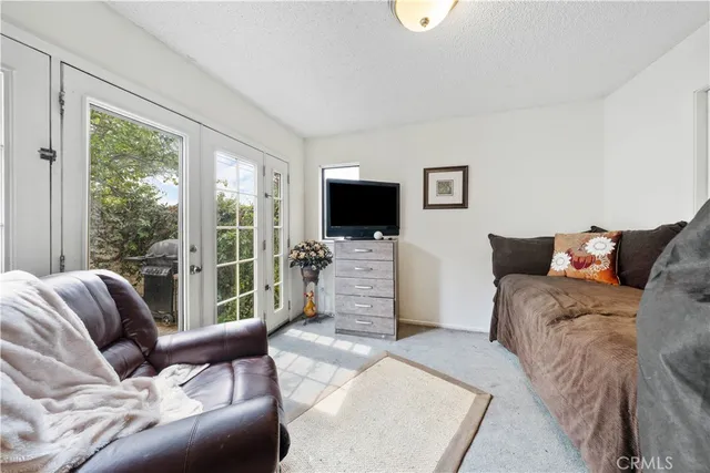 a living room with furniture a flat screen tv and a floor to ceiling window