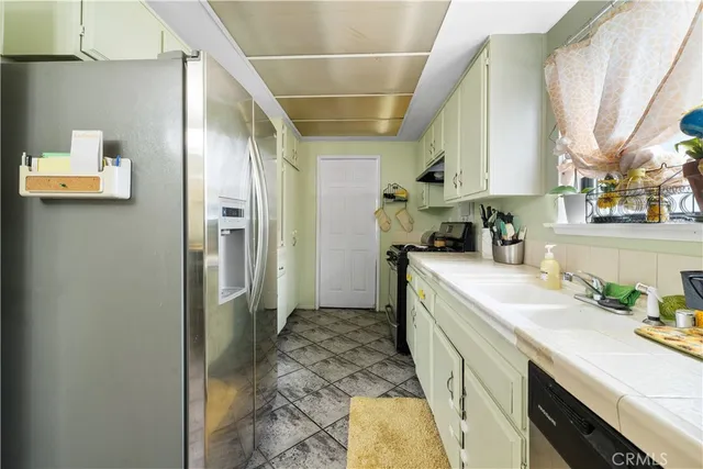 a kitchen with a sink a refrigerator and cabinets