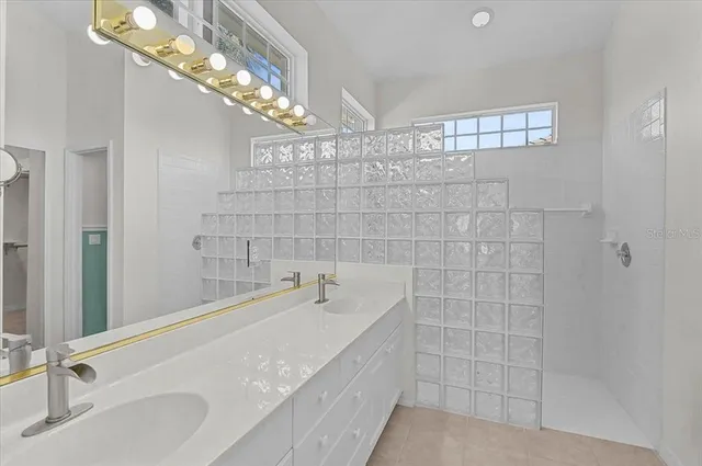 a bathroom with a sink a large mirror and shower