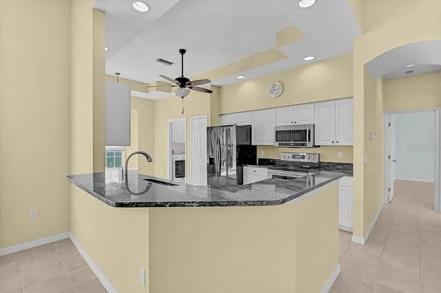 a kitchen with stainless steel appliances granite countertop a sink refrigerator and cabinets