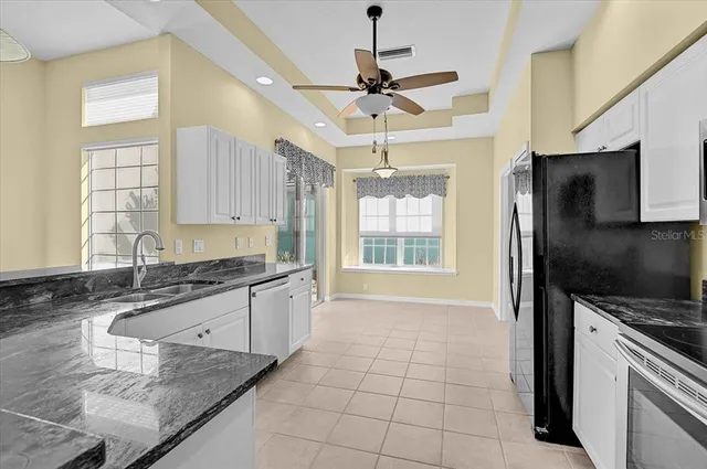a kitchen with granite countertop a sink appliances and cabinets