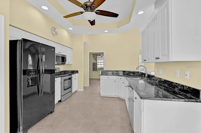a kitchen with white cabinets and stainless steel appliances