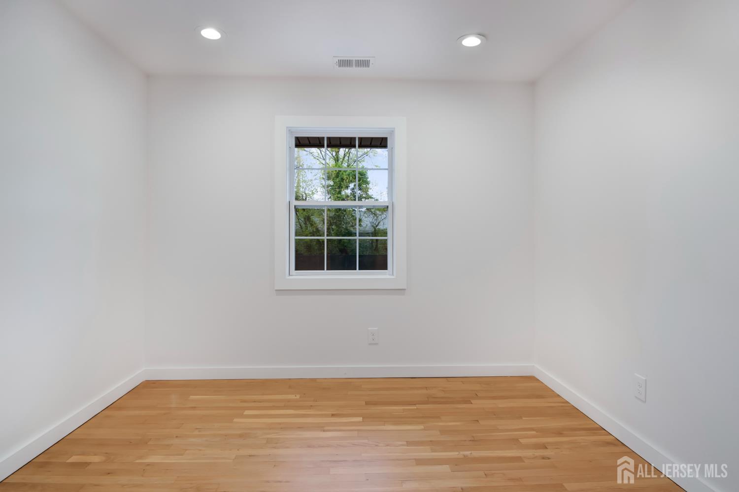 4 Morris Avenue, Unit 2A Edison, NJ 08837 - Photo 18 of 27 a view of an empty room with wooden floor and a window