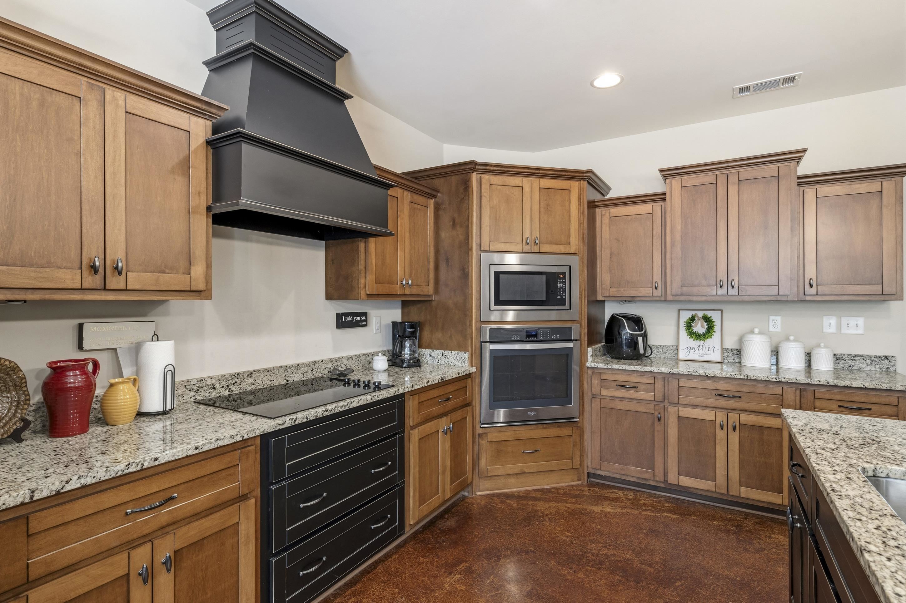 1795 Gaines Road Hernando, MS 38632 - Photo 11 of 40 a kitchen with stainless steel appliances granite countertop a stove top oven a sink dishwasher and a refrigerator with wooden cabinets