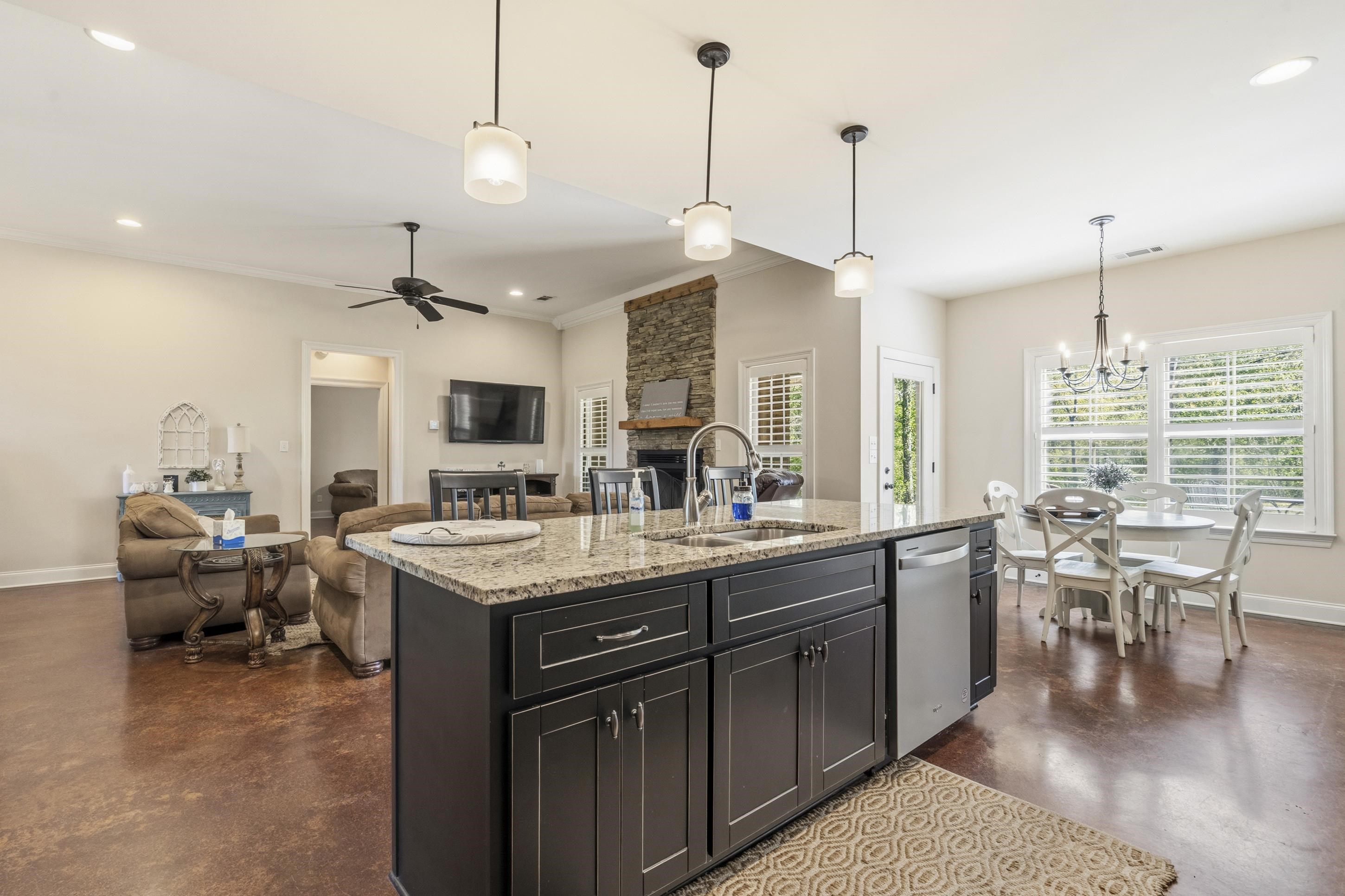 1795 Gaines Road Hernando, MS 38632 - Photo 40 of 40 a open kitchen with stainless steel appliances granite countertop a stove oven a dining table chairs and couches with wooden floor