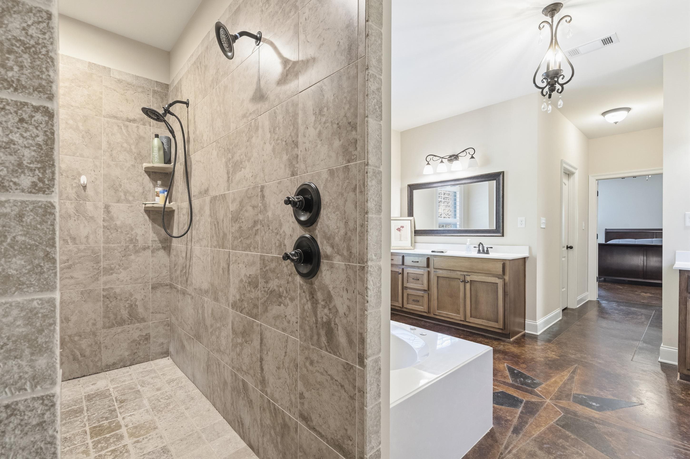 1795 Gaines Road Hernando, MS 38632 - Photo 14 of 40 a bathroom with a tub sink a mirror and shower