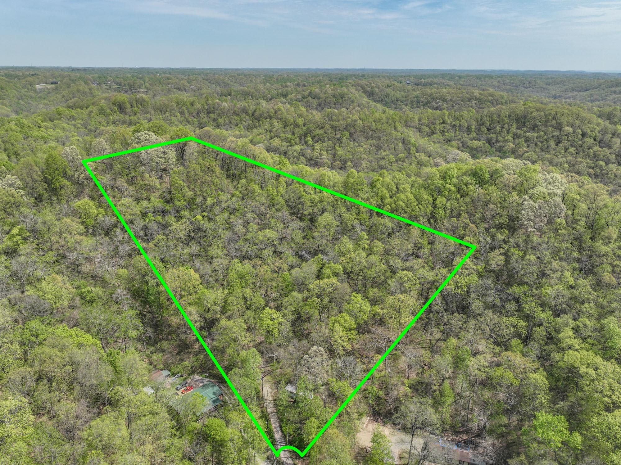 an aerial view of residential houses with outdoor space and trees