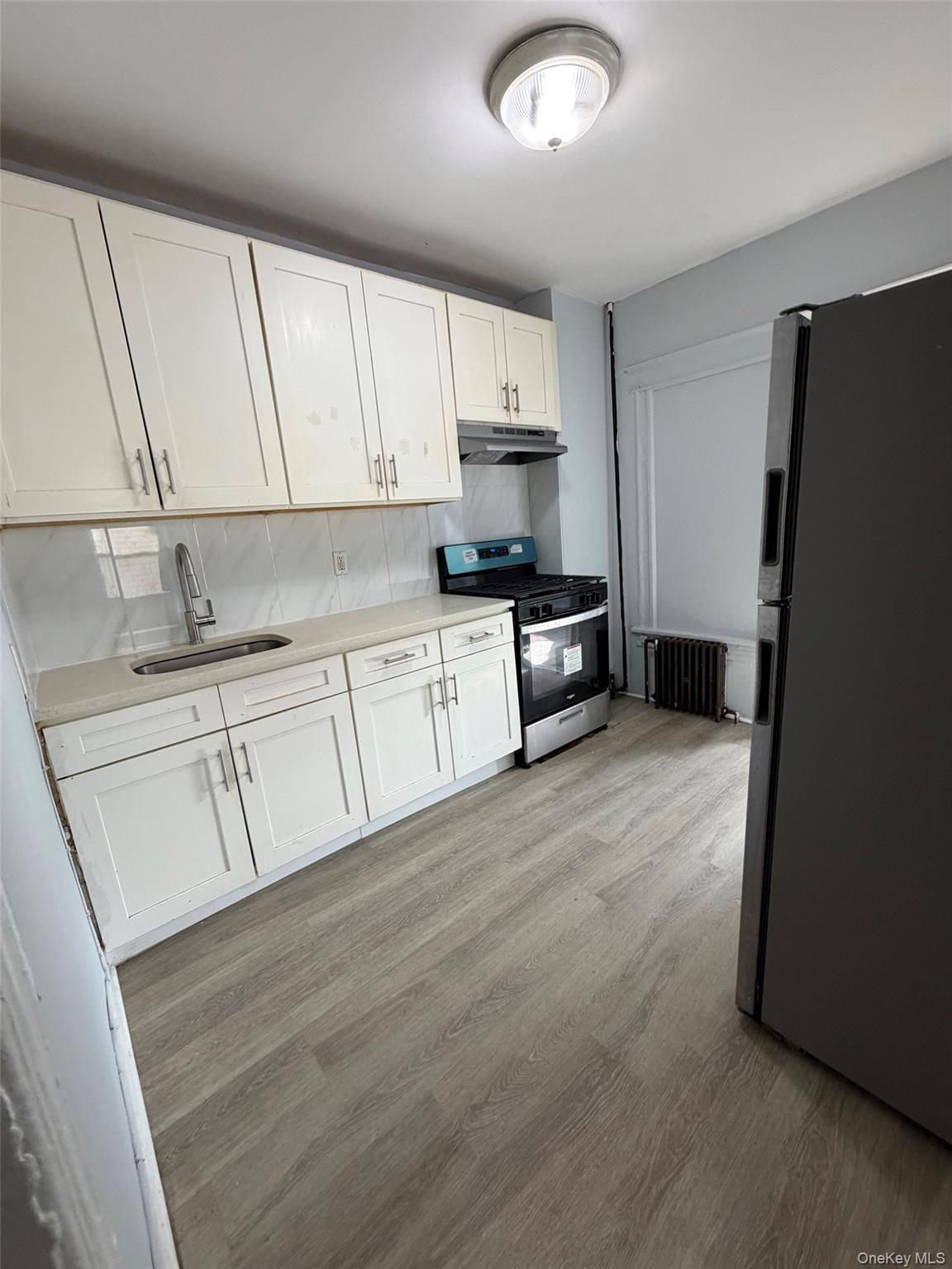 4 Ritters Lane, Unit 1 Yonkers, NY 10703 - Photo 13 of 22 a kitchen with granite countertop white cabinets and refrigerator