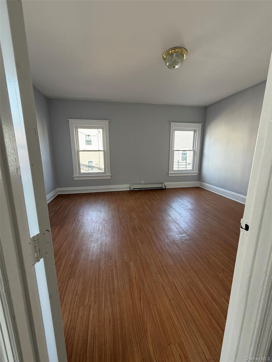 4 Ritters Lane, Unit 1 Yonkers, NY 10703 - Photo 4 of 22 a view of an empty room with wooden floor and a window