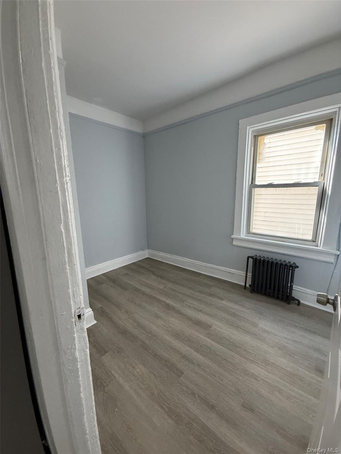 4 Ritters Lane, Unit 1 Yonkers, NY 10703 - Photo 5 of 22 a view of an empty room with wooden floor and a window