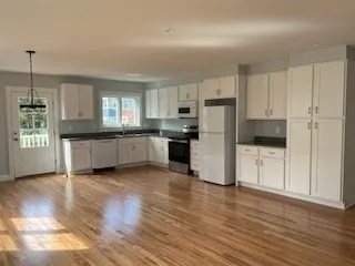 a kitchen with granite countertop a refrigerator and a stove top oven