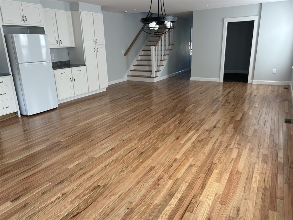29 Orange Street, Unit B Boston, MA 02131 - Photo 5 of 23 a view of a kitchen with wooden floor and staircase
