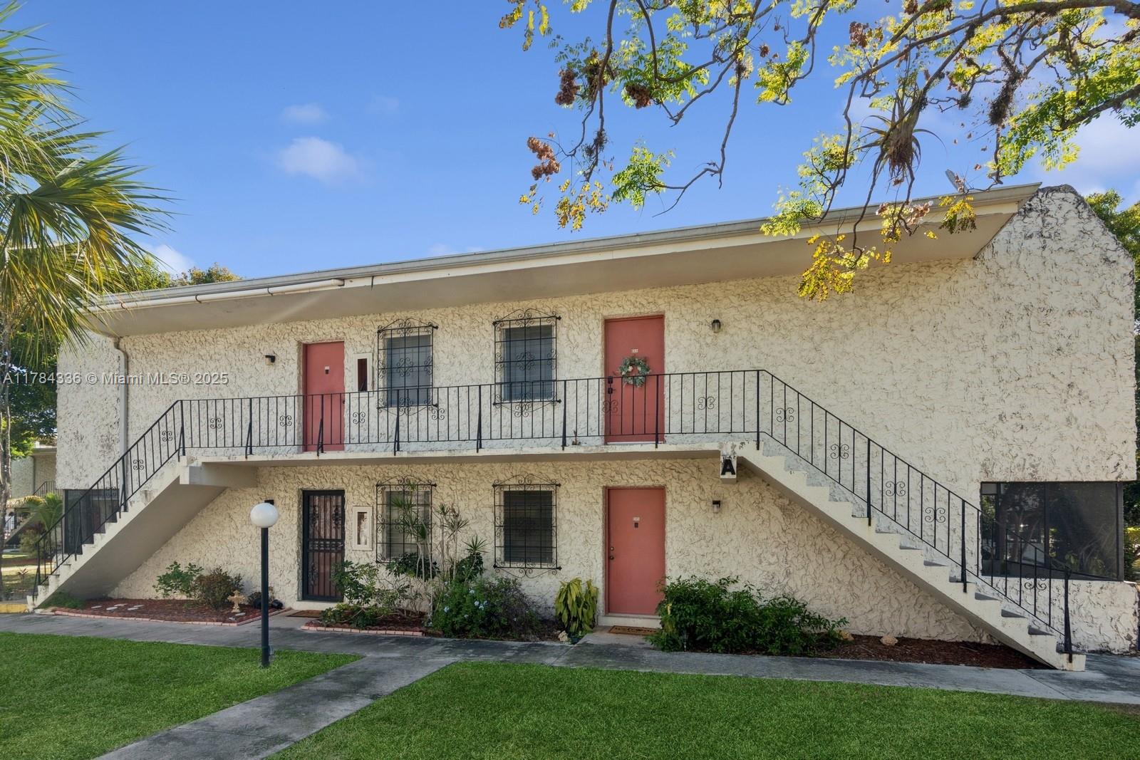 8701 Southwest 141st Street, Unit A5 Palmetto Bay, FL 33176 - Photo 14 of 19 a front view of a house with a yard