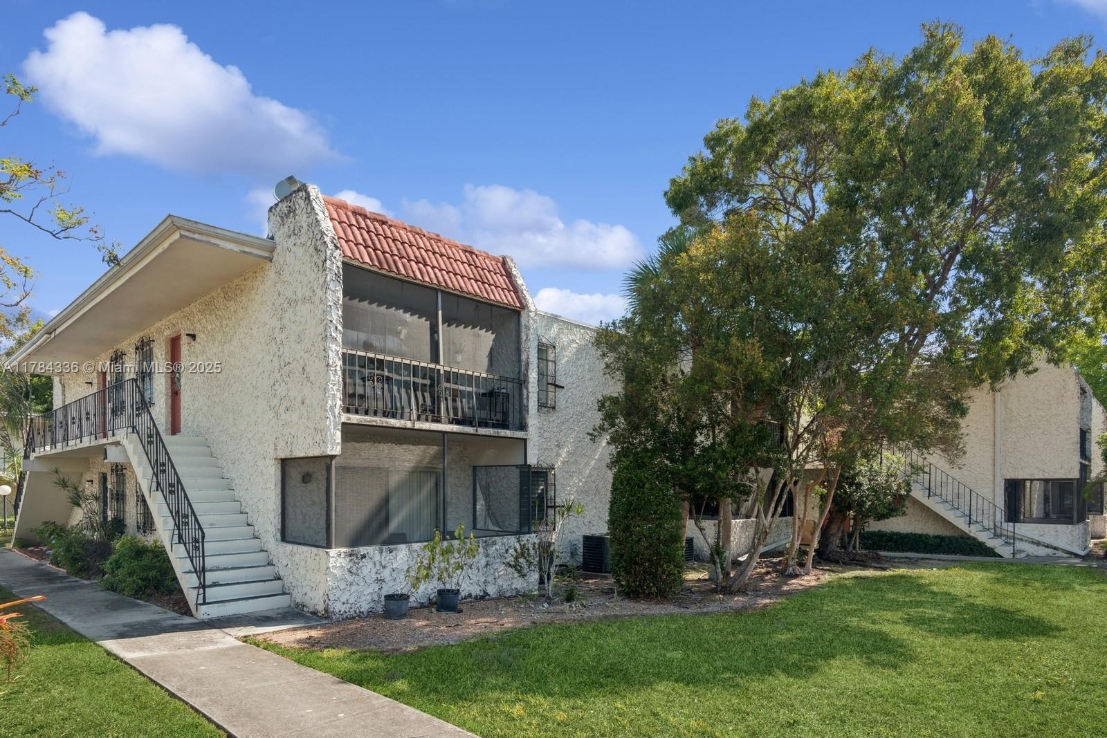 8701 Southwest 141st Street, Unit A5 Palmetto Bay, FL 33176 - Photo 15 of 19 a front view of a house with garden
