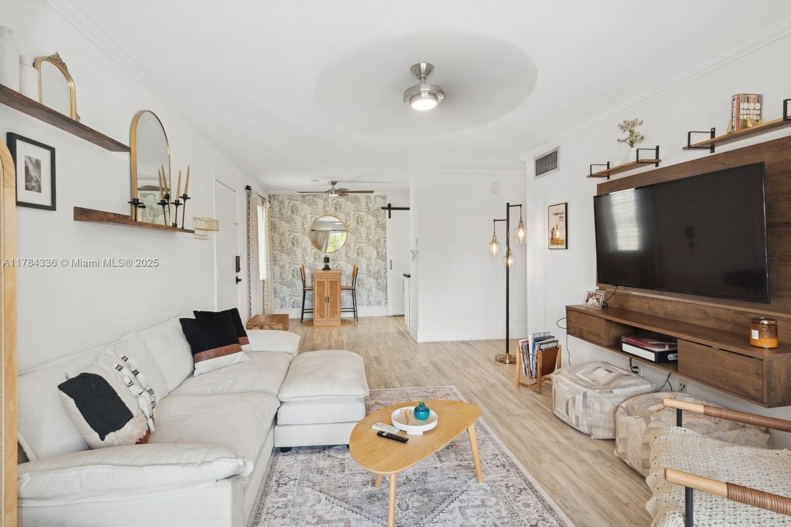 8701 Southwest 141st Street, Unit A5 Palmetto Bay, FL 33176 - Photo 3 of 19 a living room with furniture and a flat screen tv