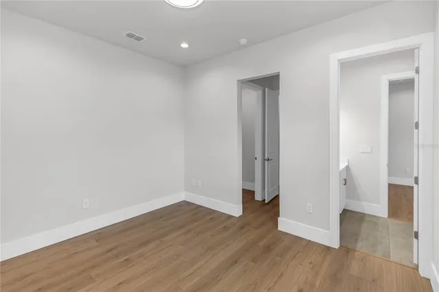 a view of a room with wooden floor and white walls