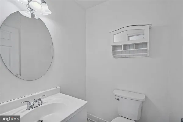 a bathroom with a sink a toilet and a mirror