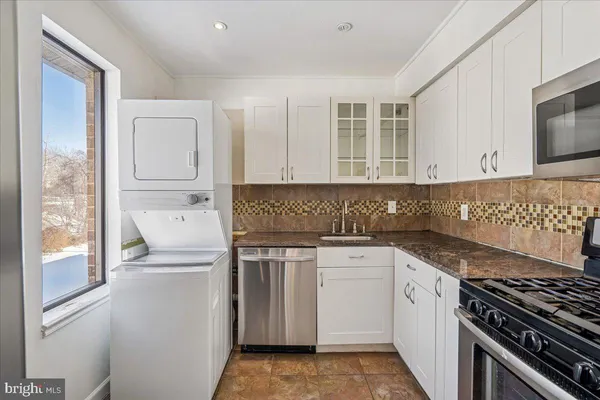 a kitchen with white cabinets and appliances