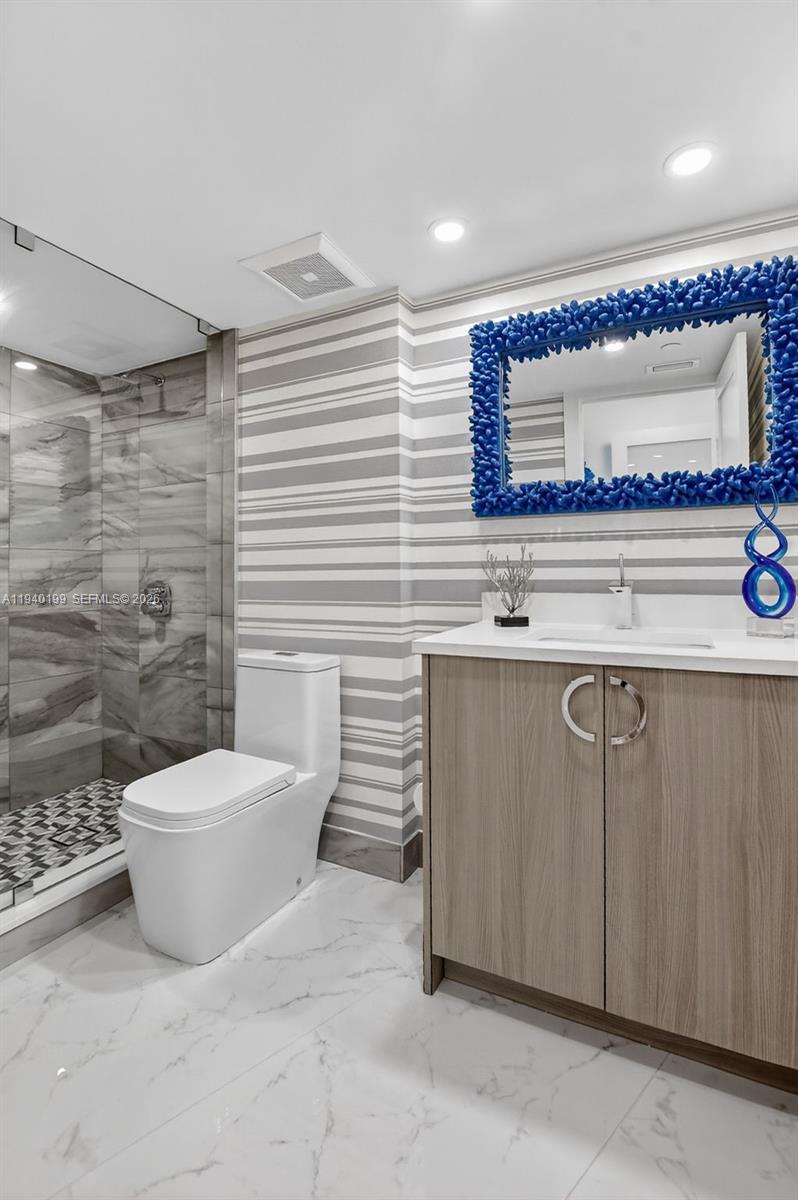 4545 North Ocean Boulevard, Unit 8B Boca Raton, FL 33431 - Photo 54 of 78 a bathroom with a toilet a sink and mirror