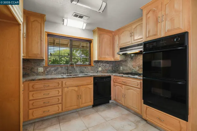 a kitchen with granite countertop white cabinets and stainless steel appliances