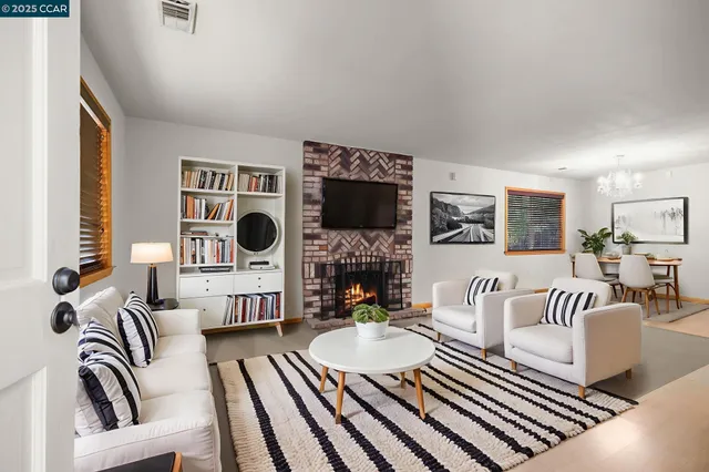 a living room with furniture a flat screen tv and a fireplace