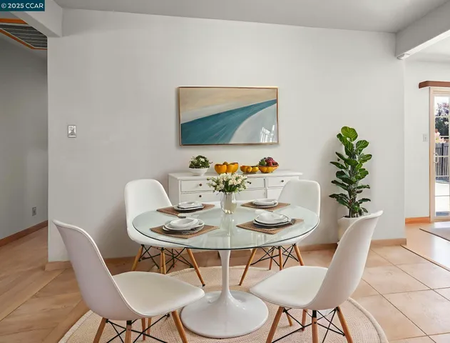 a dining room with furniture and a potted plant
