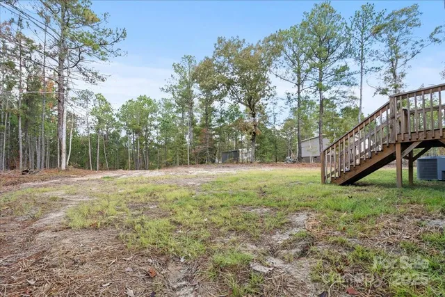 a view of a house with a backyard and furniture