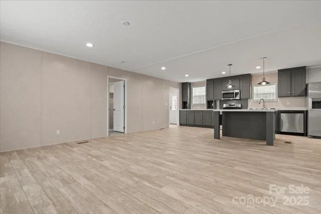 a view of kitchen with kitchen island and stainless steel appliances