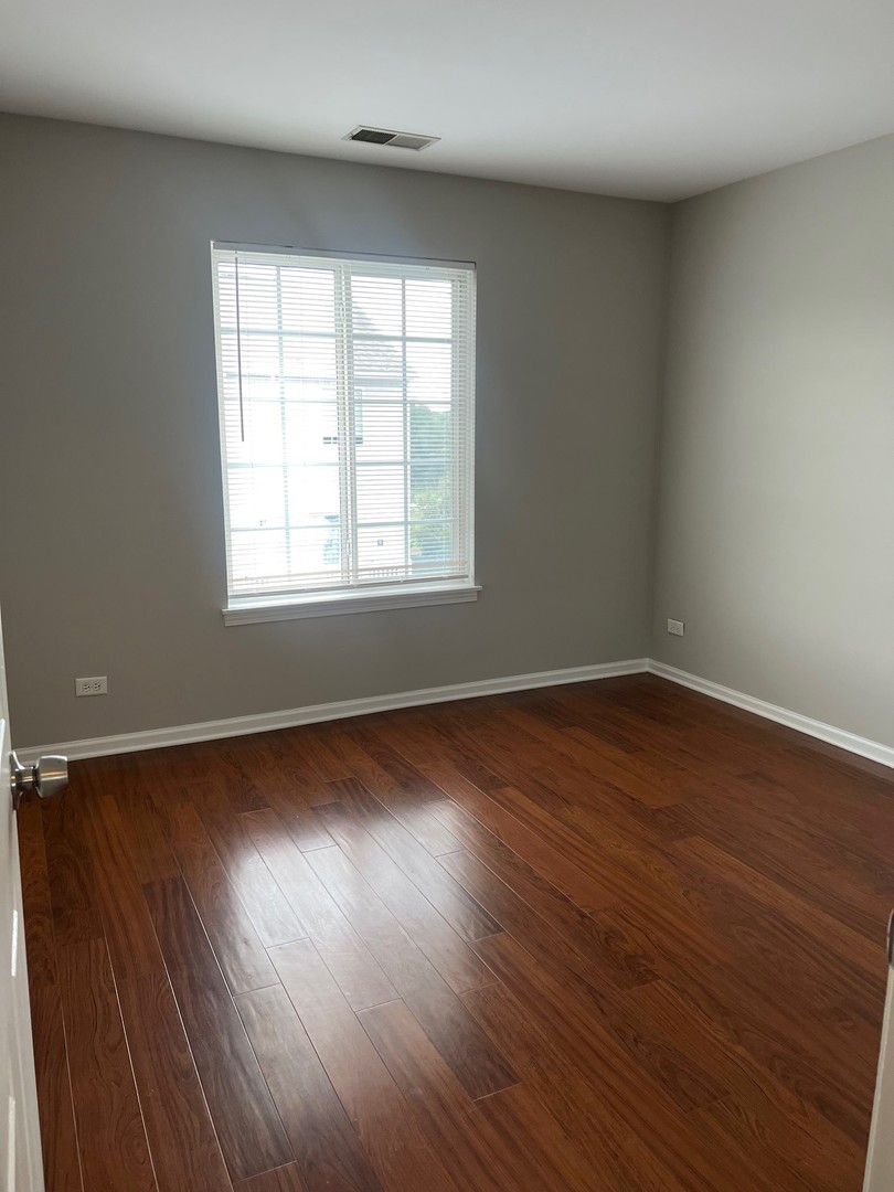 3393 Ravinia Circle Aurora, IL 60504 - Photo 12 of 14 an empty room with wooden floor and windows