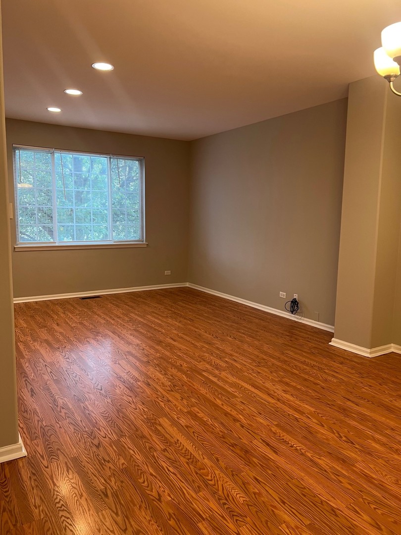 3393 Ravinia Circle Aurora, IL 60504 - Photo 2 of 14 an empty room with wooden floor and windows