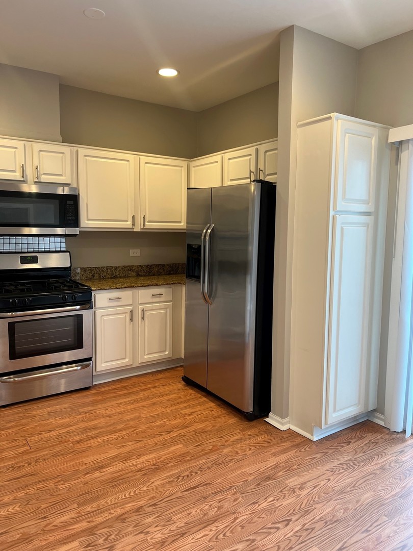 3393 Ravinia Circle Aurora, IL 60504 - Photo 6 of 14 a kitchen with stainless steel appliances a refrigerator and a stove top oven