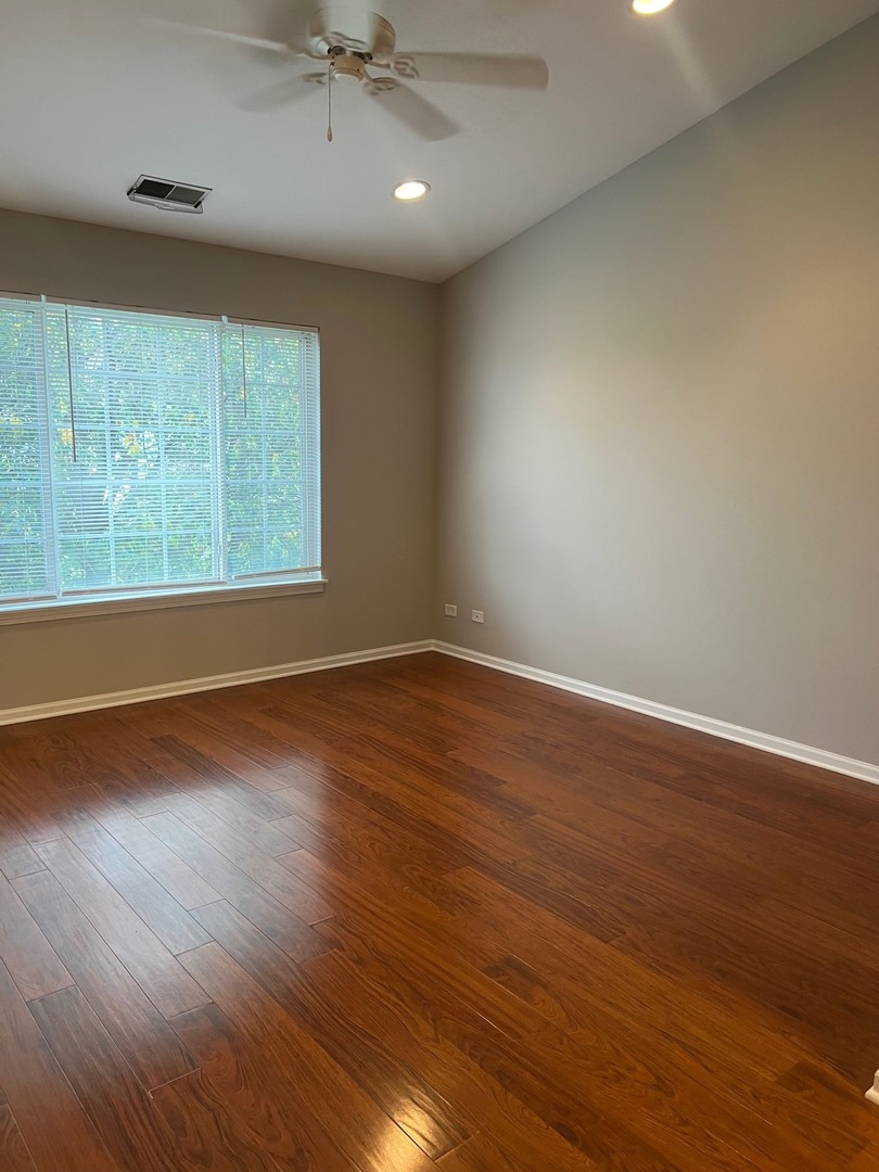 3393 Ravinia Circle Aurora, IL 60504 - Photo 8 of 14 an empty room with wooden floor and windows