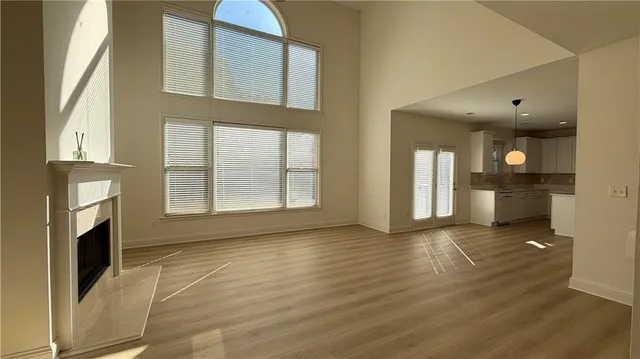 a kitchen with stainless steel appliances granite countertop a refrigerator a sink dishwasher a stove and white countertops with wooden floor