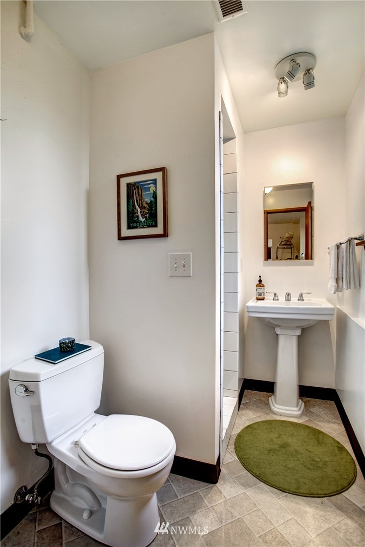 7620 South 115th Street Seattle, WA 98178 - Photo 27 of 33 a bathroom with a toilet sink and mirror