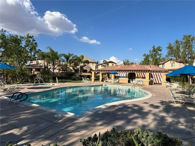 a patio with a table and chairs under an umbrella