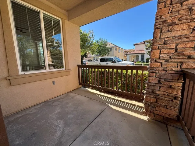 a view of a porch with a floor to ceiling window next to a yard