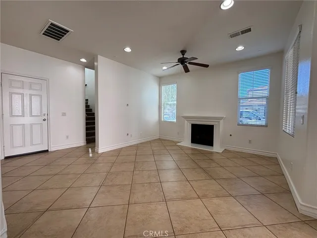 an empty room with a fireplace and windows