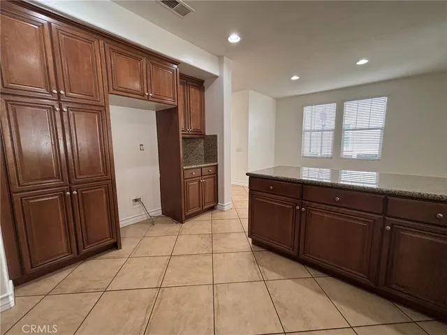 a kitchen with granite countertop cabinets and refrigerator