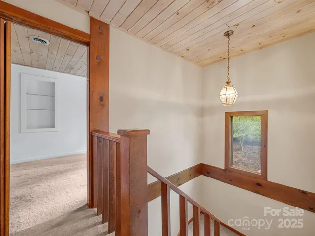 an empty room with windows and ceiling fan