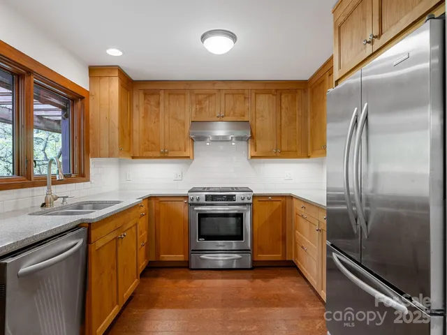 a kitchen with stainless steel appliances granite countertop a sink stove and refrigerator