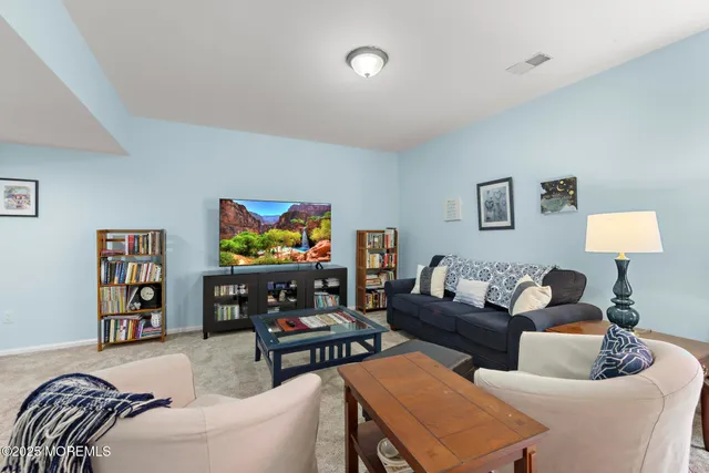 a living room with furniture a bookshelf and a flat screen tv