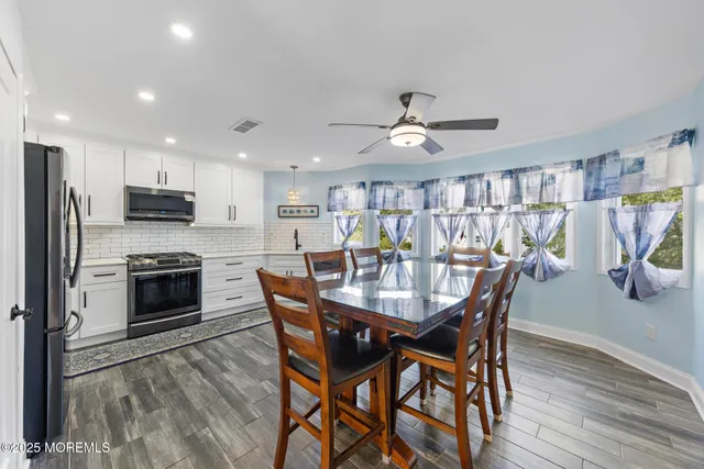 a view of a dining room with furniture and a kitchen view