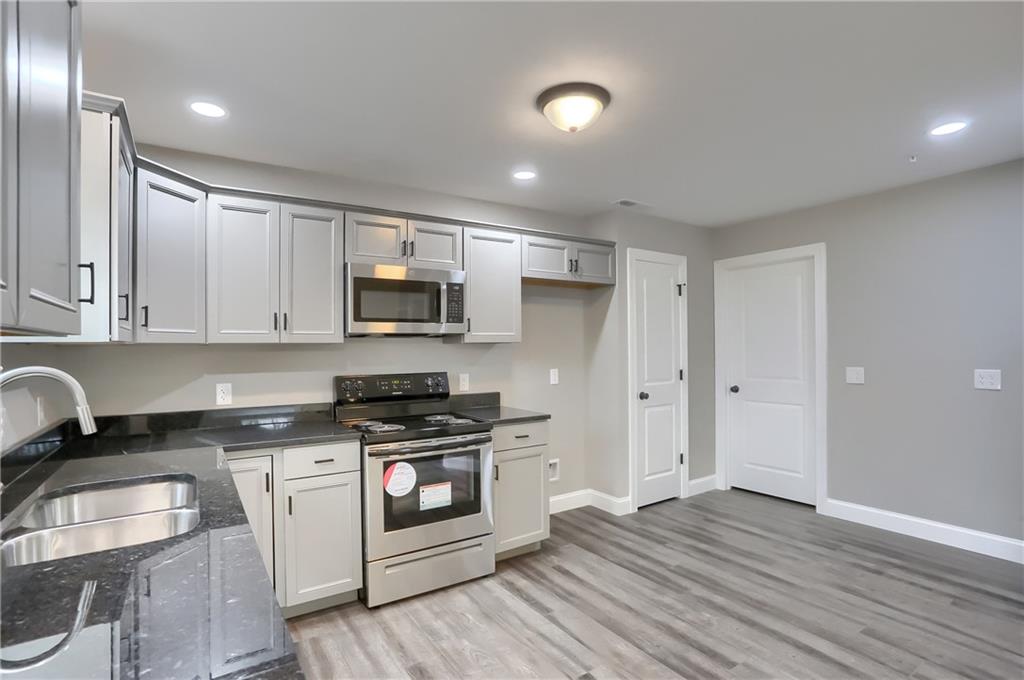 337 Kittery Ridge Drive, Unit D New Castle, PA 16101 - Photo 12 of 25 a kitchen with granite countertop a stove top oven sink and cabinets