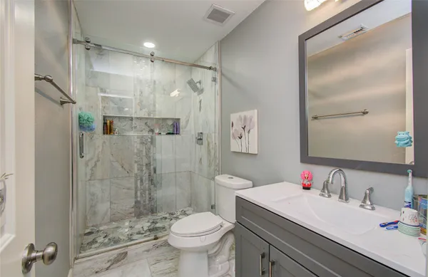 a bathroom with a sink toilet vanity and shower
