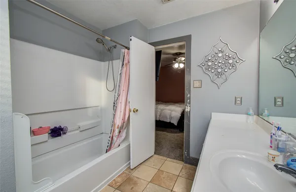 a bathroom with a tub sink and shower