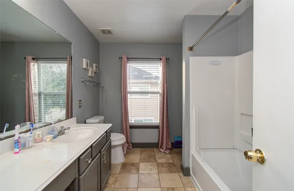 a bathroom with a sink a tub and a mirror