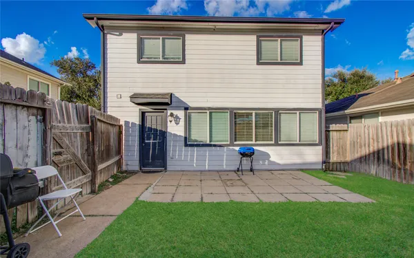 a view of house with backyard and outdoor seating